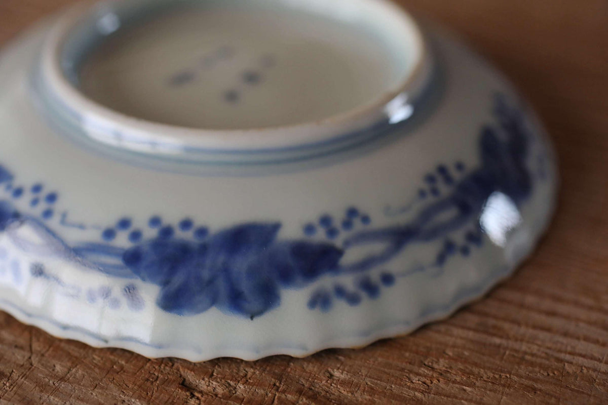 A close-up image of a blue and white ceramic plate with a floral design, resting on a wooden surface.