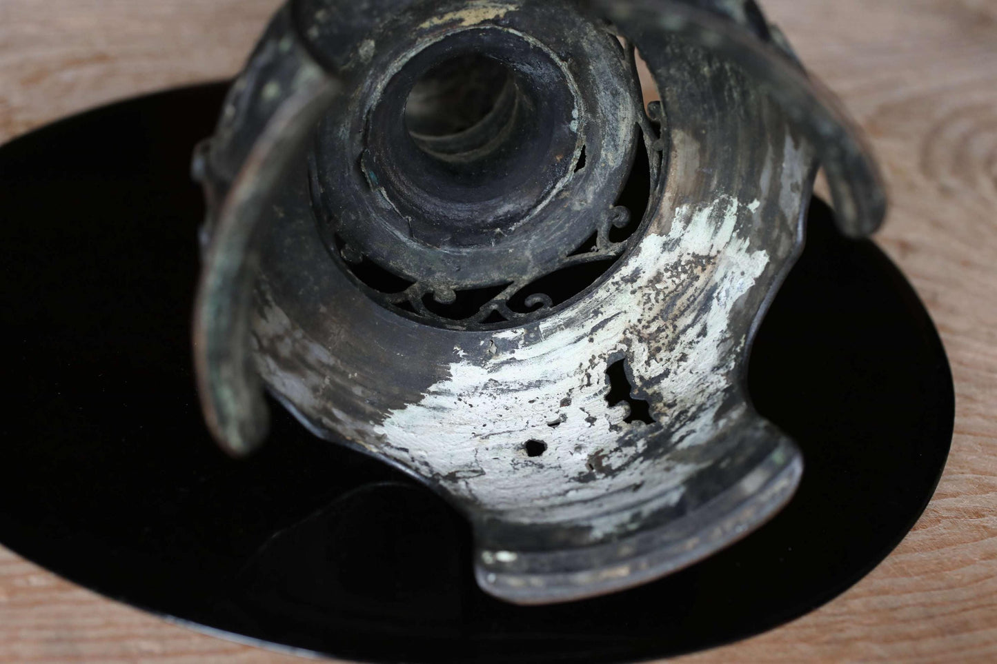 a close-up view of a metal object, possibly a piece of art or a decorative item, with a black background.