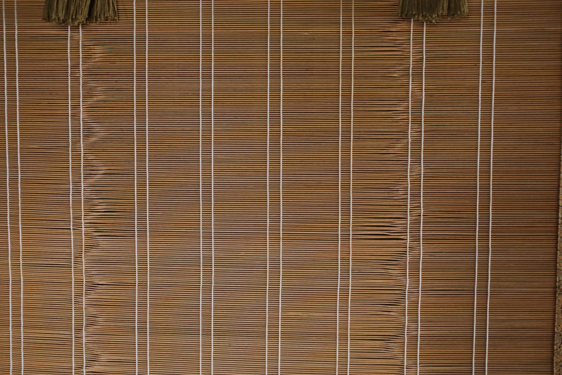 a close-up view of a bamboo blind with vertical slats, creating a textured and patterned appearance.