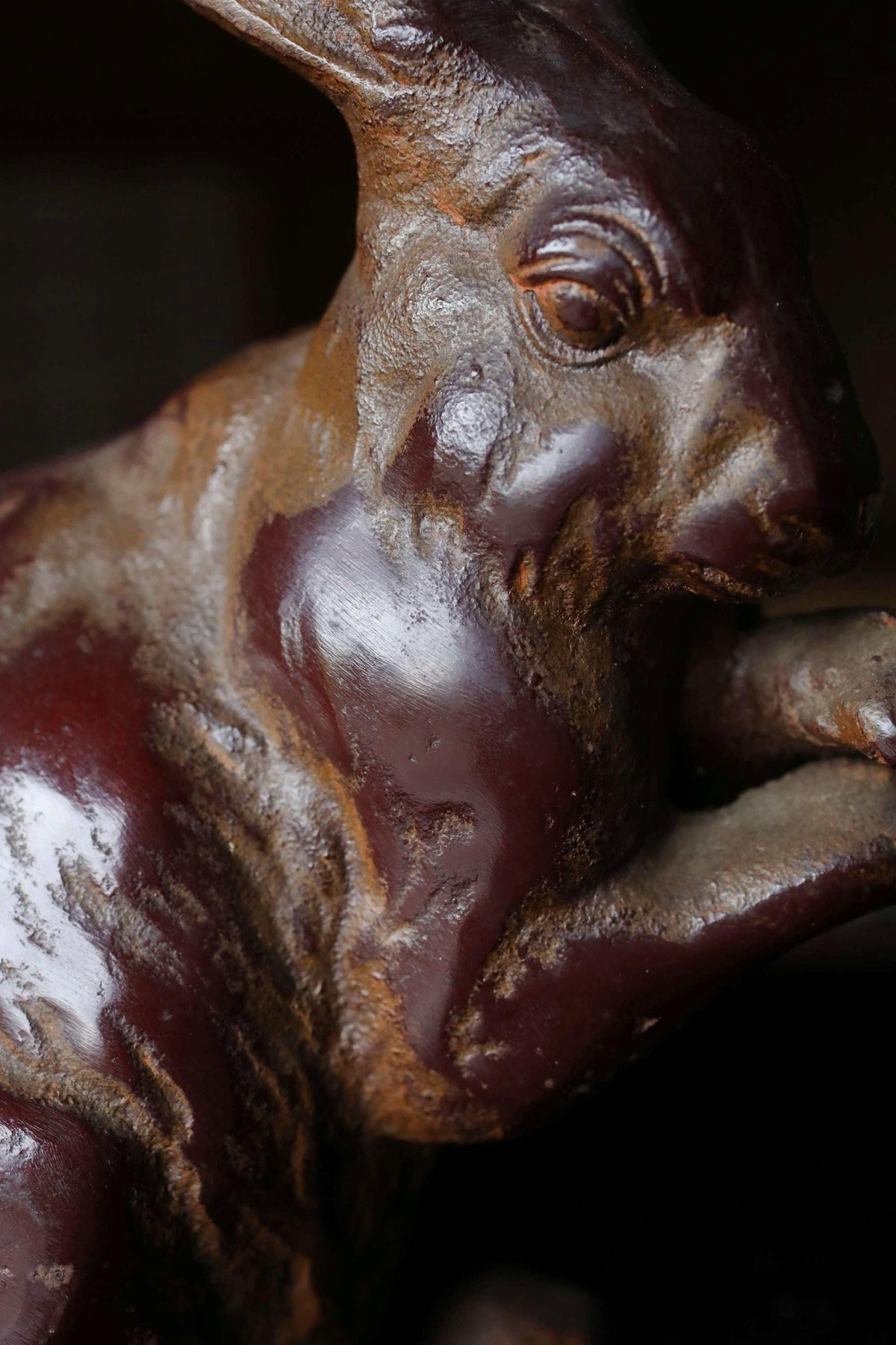 A close-up view of a rusted metal sculpture of a rabbit or hare, with a reddish-brown patina covering its surface.