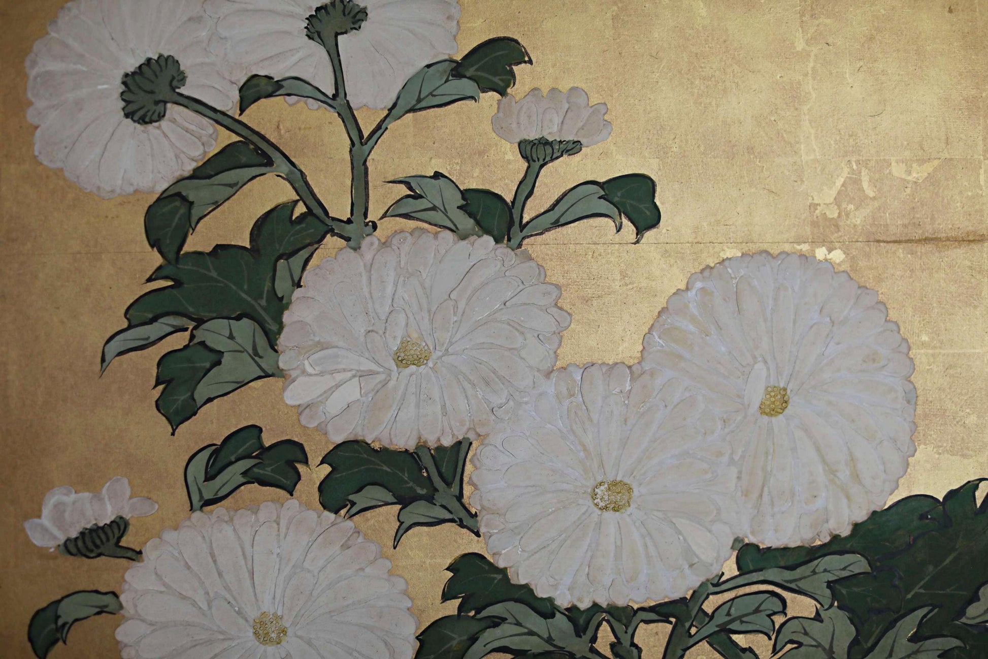 a close-up view of a group of white flowers with green leaves, arranged in a decorative manner.