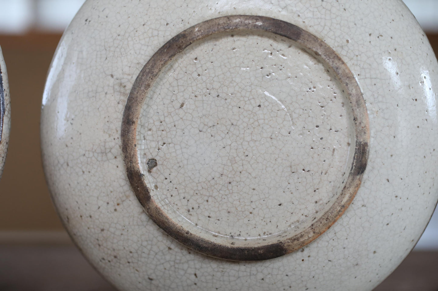 A close-up view of a white ceramic bowl with a brown rim, showing the intricate texture and design of the bowl.