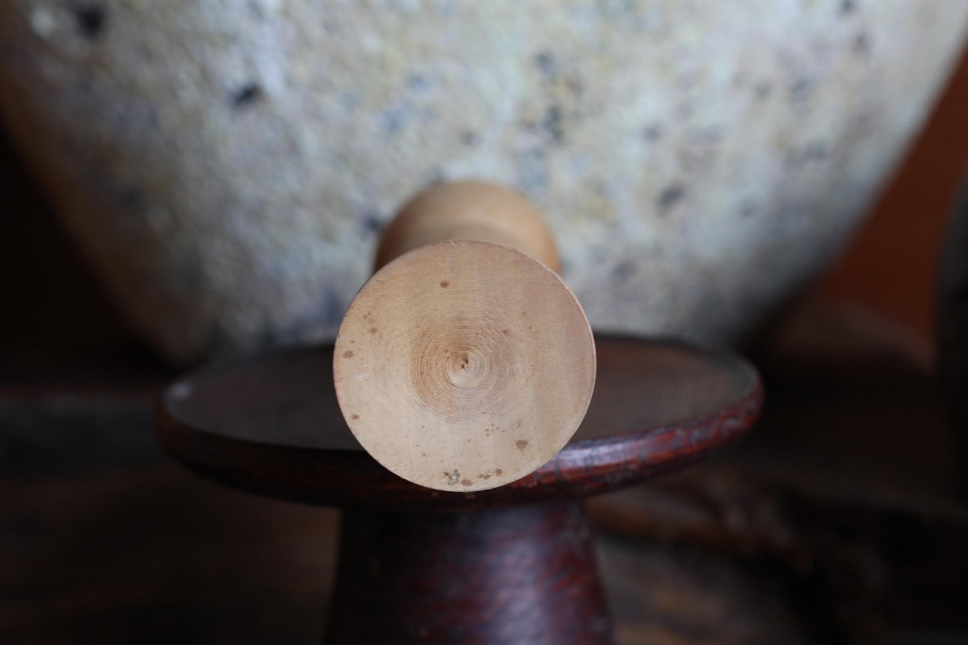 a wooden object with a circular shape, placed on a dark surface.
