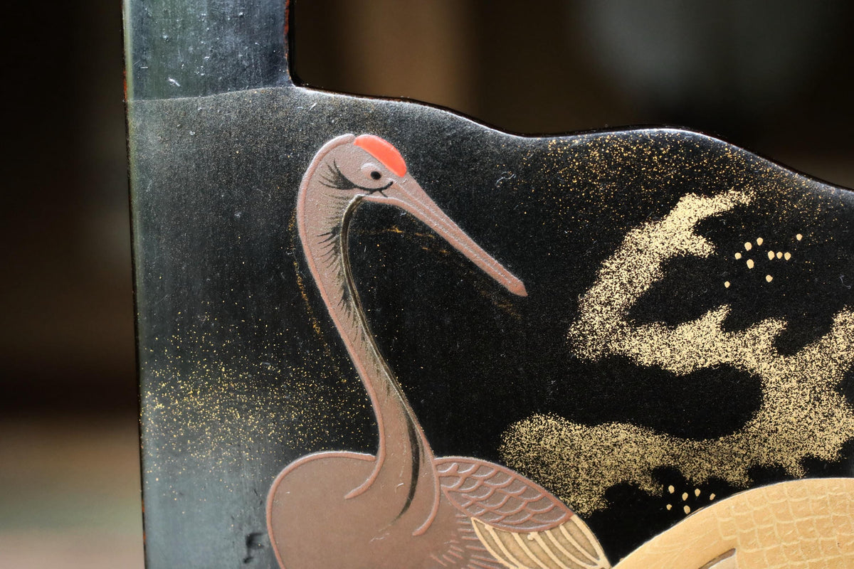 a close-up view of a decorative bird painted on a dark background.