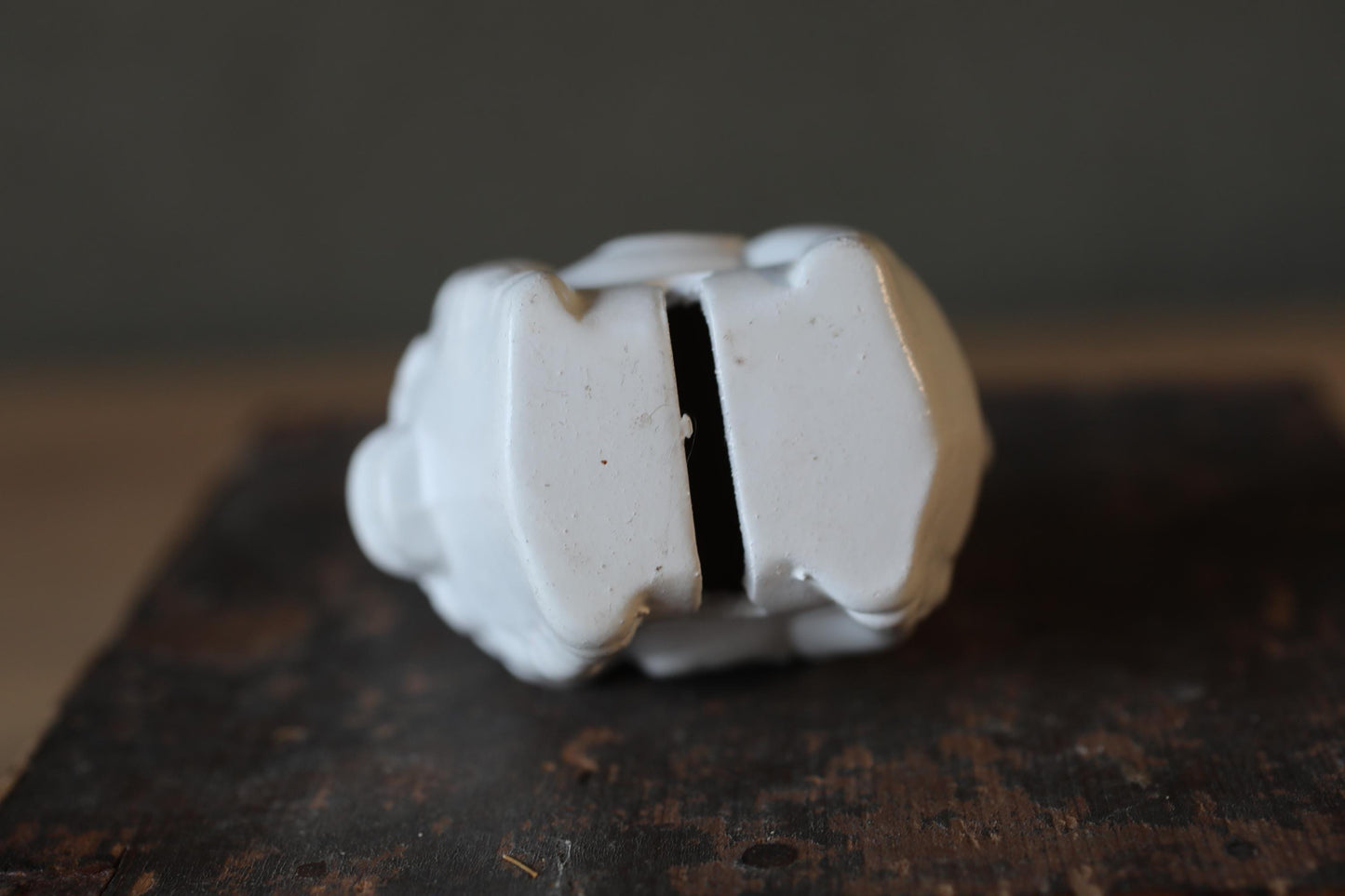 A white, three-dimensional object is shown in the image, resting on a wooden surface.