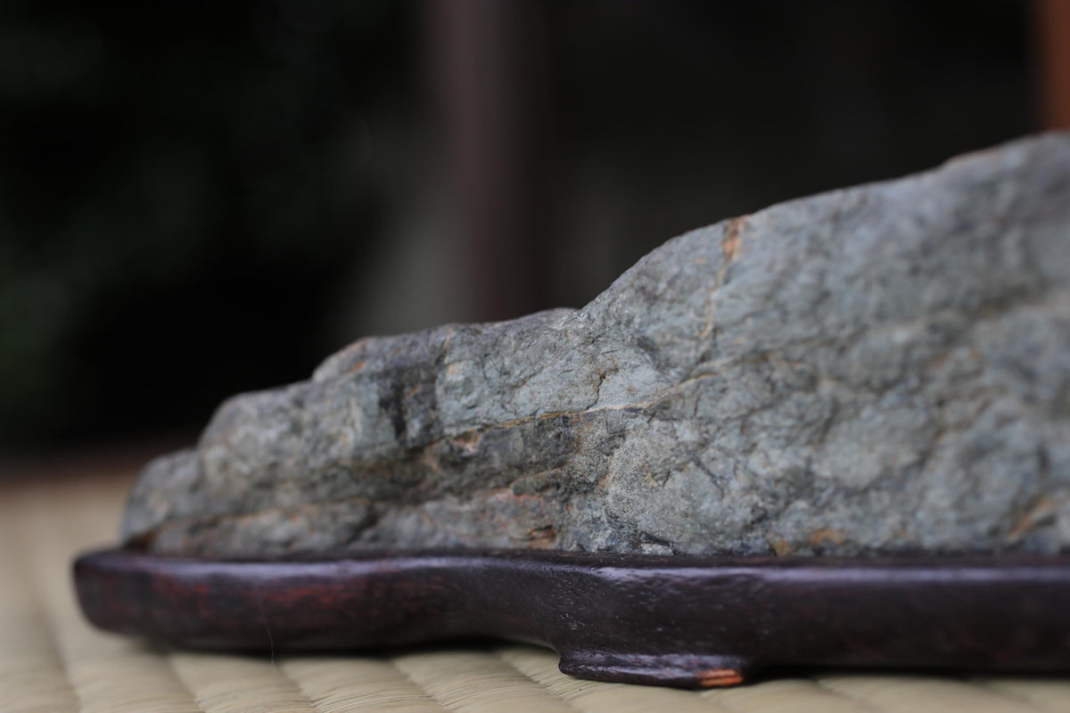 A close-up image of a rock or stone placed on a wooden base or stand.