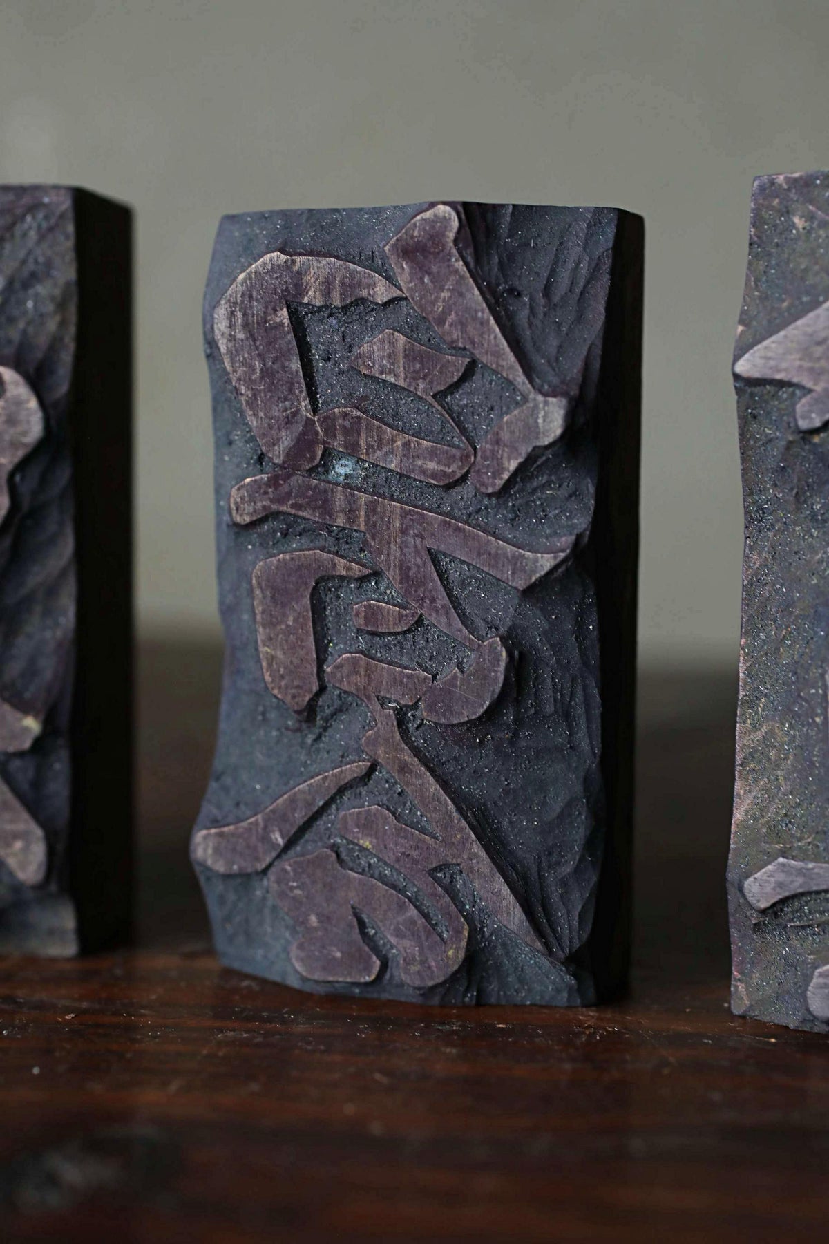 a close-up view of a dark-colored, textured block with a carved design on it.