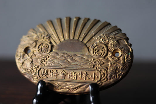 a close-up view of a decorative golden plaque or medallion with intricate designs and patterns.