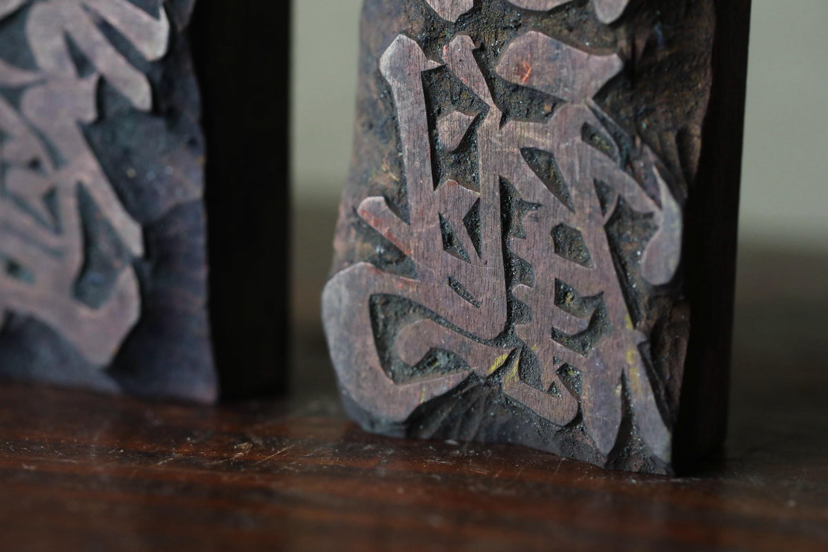 a close-up view of a dark wooden block with an intricate, carved design.