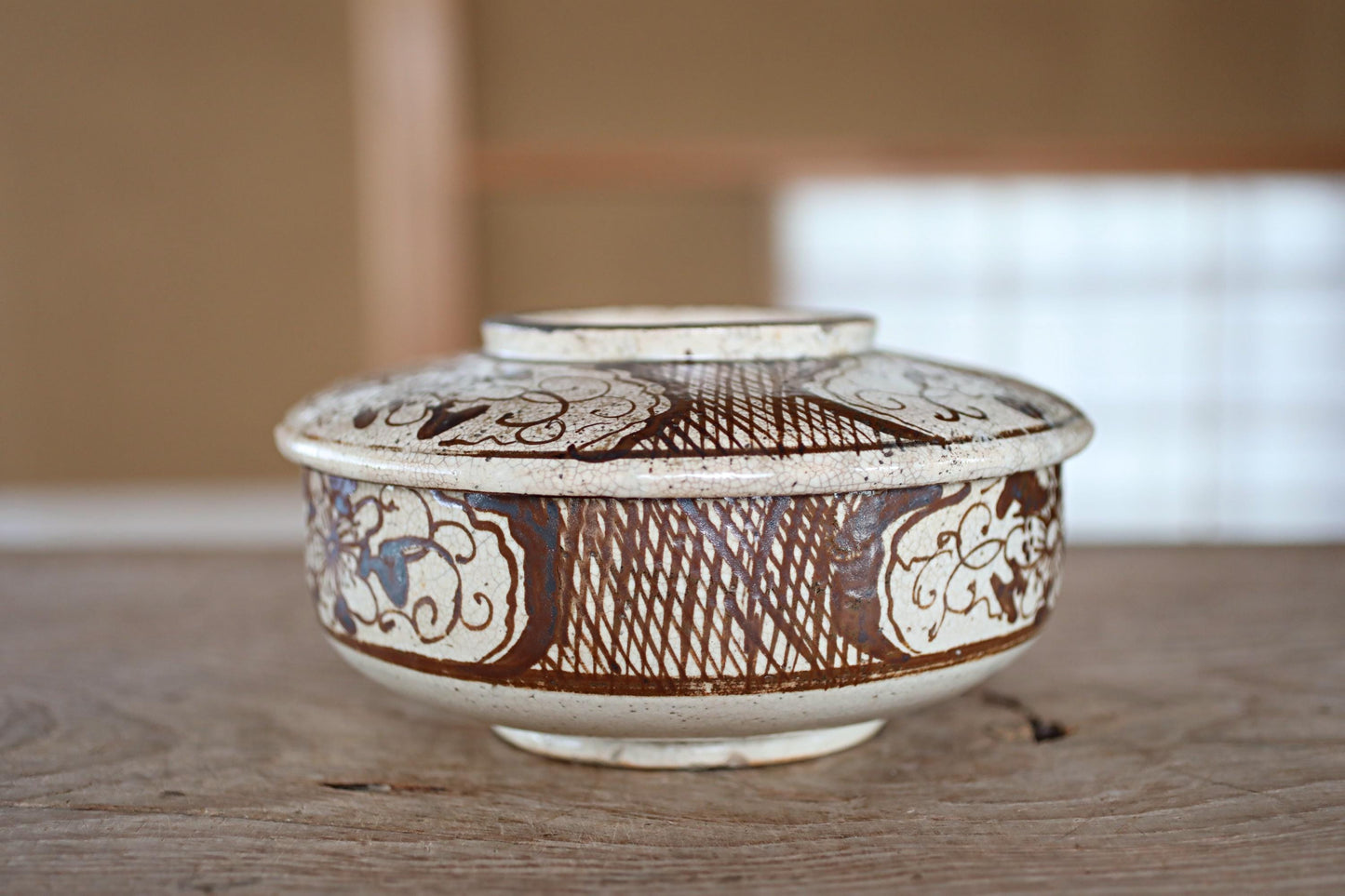 A decorative ceramic bowl with intricate patterns and designs, sitting on a wooden surface.