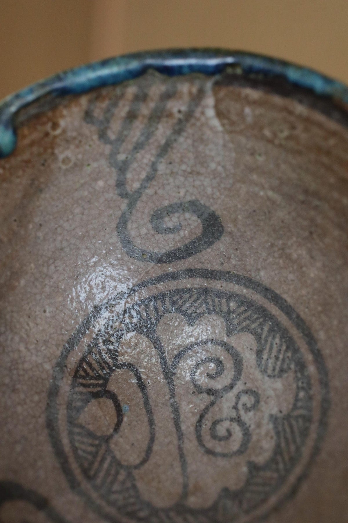 a close-up view of a ceramic bowl or vase with a decorative design featuring a swirl pattern.