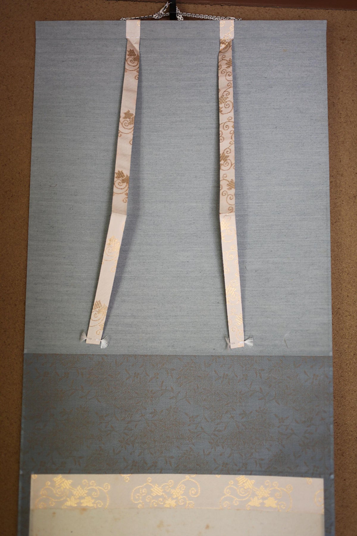 a gray wall with two white straps hanging from it.