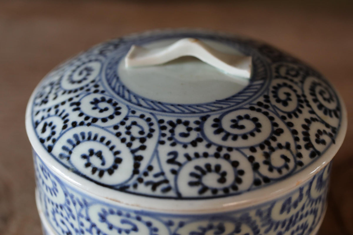 A close-up view of a decorative ceramic lid with a blue and white floral pattern.