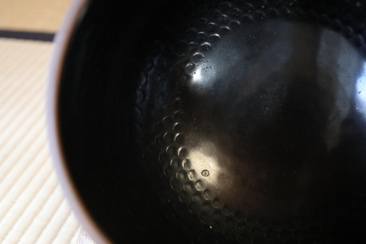 a close-up view of a black, textured surface with a hole pattern.