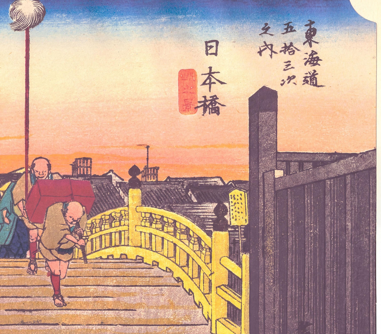 The image is a Japanese woodblock print depicting a man carrying a large red object, possibly a box or crate, while walking on a wooden bridge. The bridge is adorned with a yellow railing and is set against a backdrop of a city skyline at sunset. The sky is filled with warm hues of orange and yellow, creating a serene atmosphere. The print also includes Japanese text, which appears to be a description or caption related to the scene.