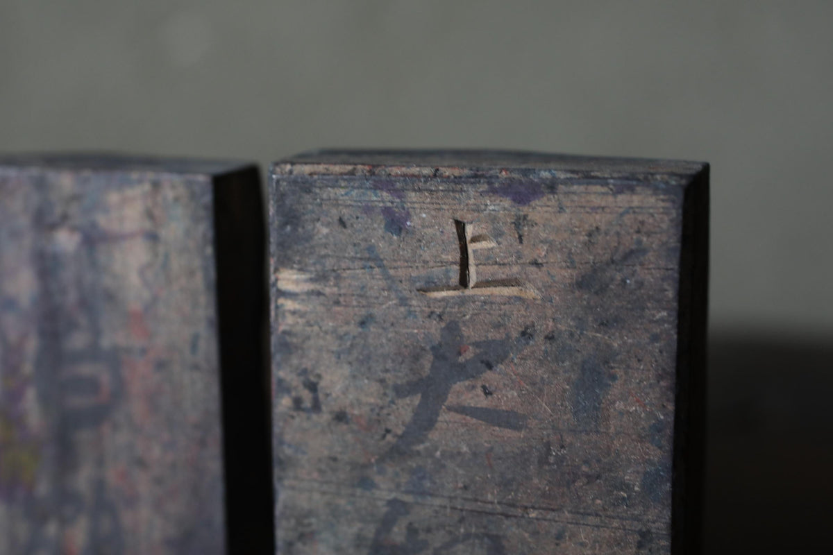 a close-up view of a metal surface with a carved symbol or logo, possibly a brand or company name.