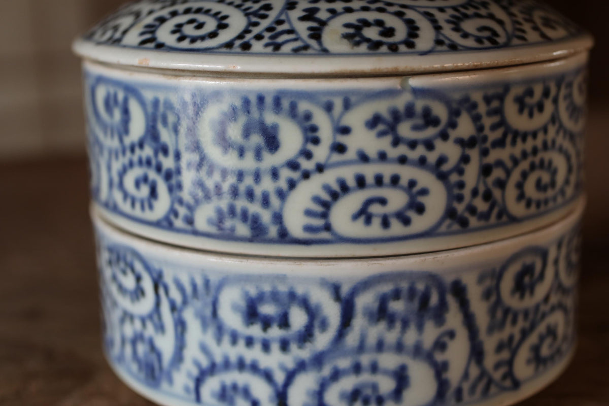A close-up image of a decorative ceramic container with a blue and white floral pattern.