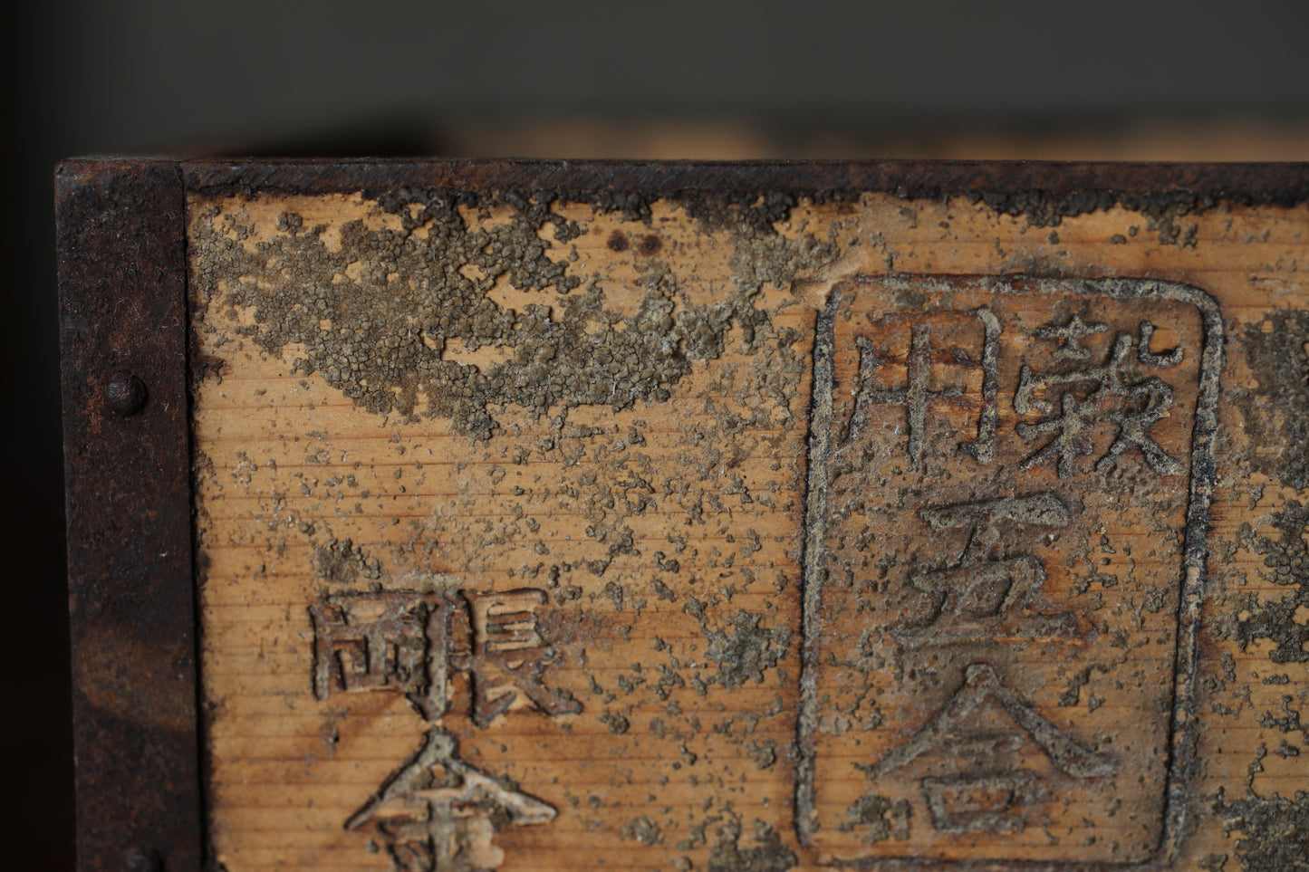 a close-up view of a weathered wooden surface with some text and symbols carved into it.