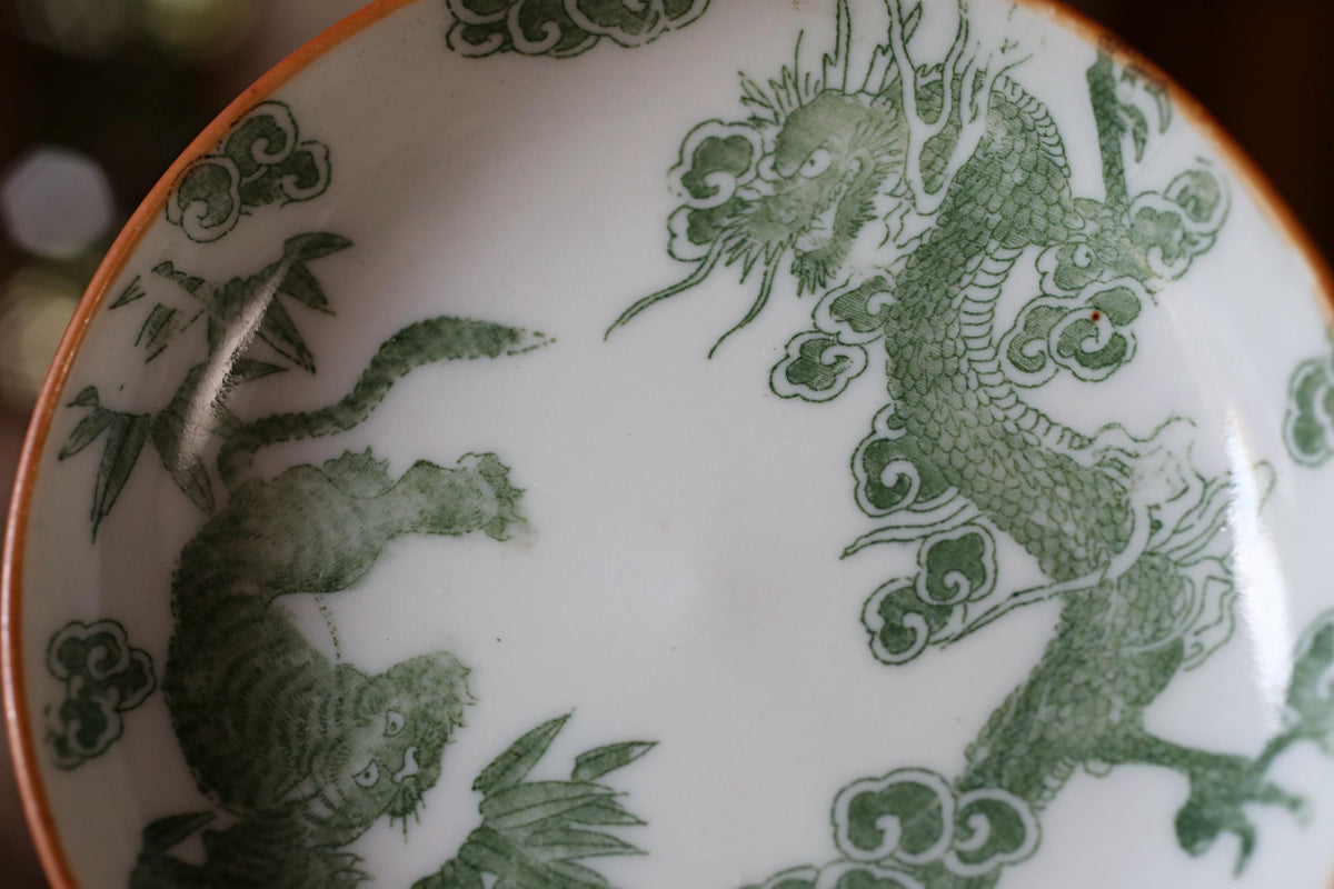 A close-up image of a decorative plate with a dragon and tiger design.