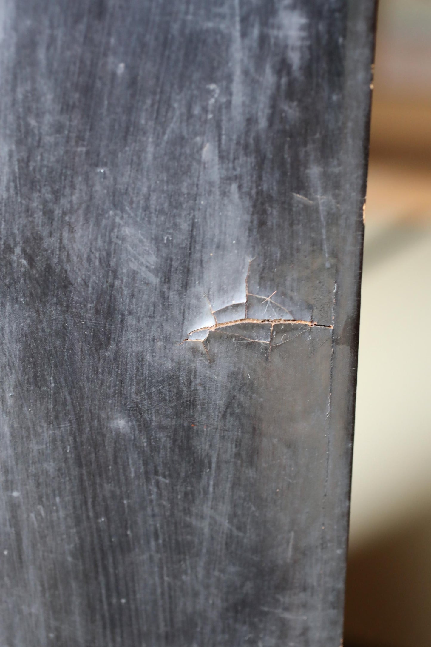 a close-up view of a black, textured surface with a small, cracked or chipped area.