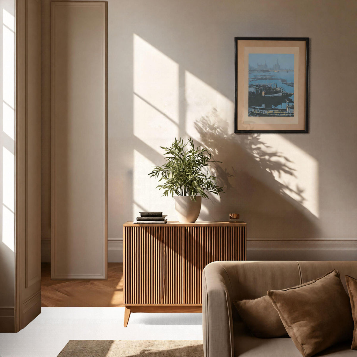a cozy living room with a wooden cabinet, a sofa, and a framed picture of a ship on the wall. The room is bathed in natural light streaming in from a window, creating a warm and inviting atmosphere.