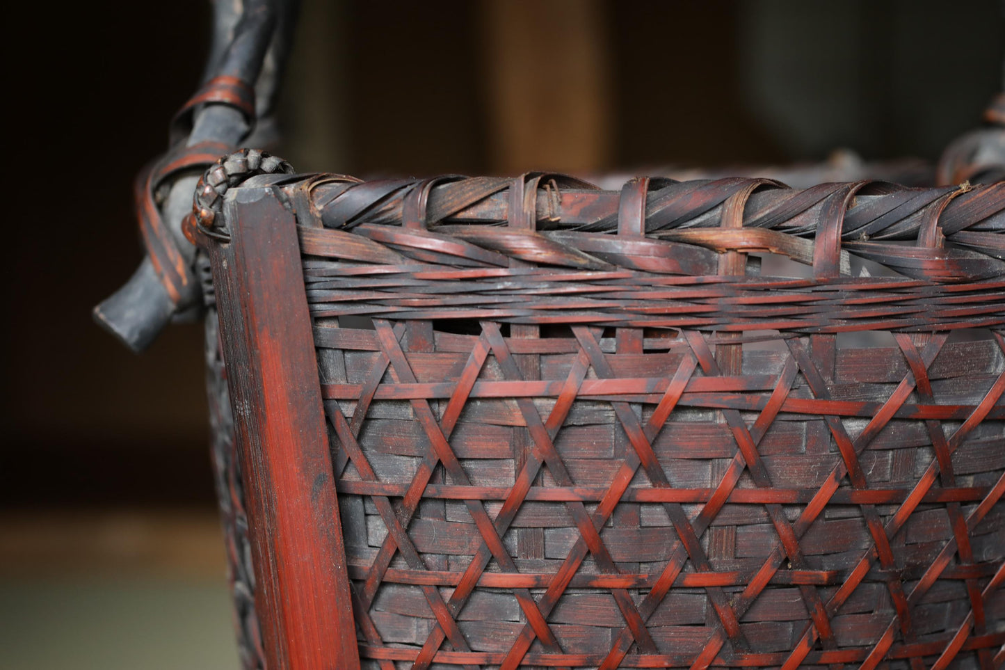 A close-up view of a woven basket with a reddish-brown color and intricate patterns.