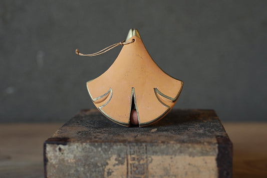 a small, orange-colored object with a pointed top, sitting on a wooden surface.