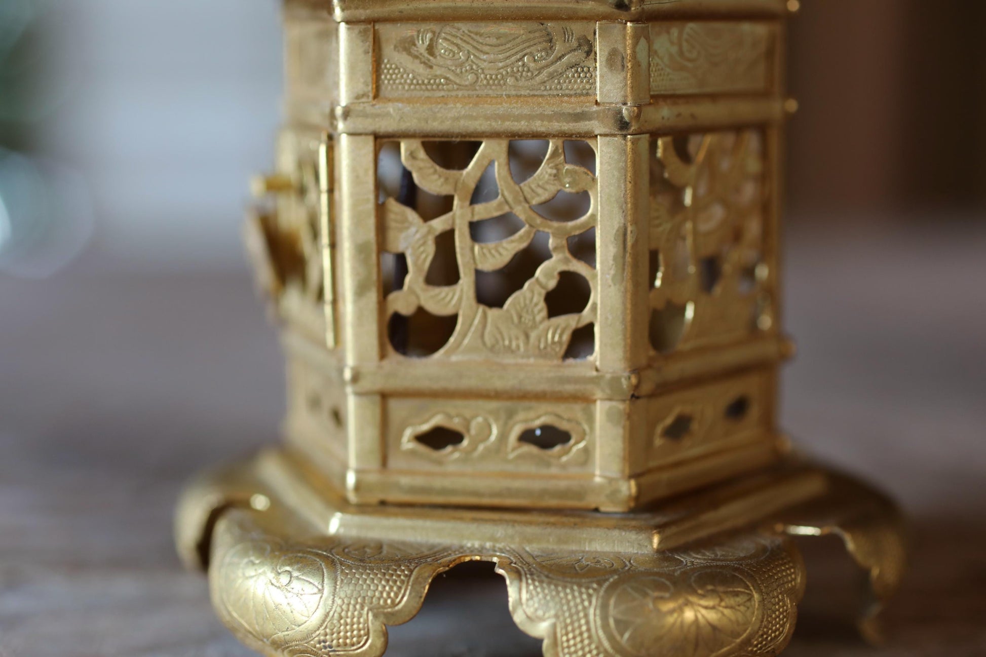 A close-up view of a decorative golden object, possibly a vase or sculpture, with intricate patterns and designs.