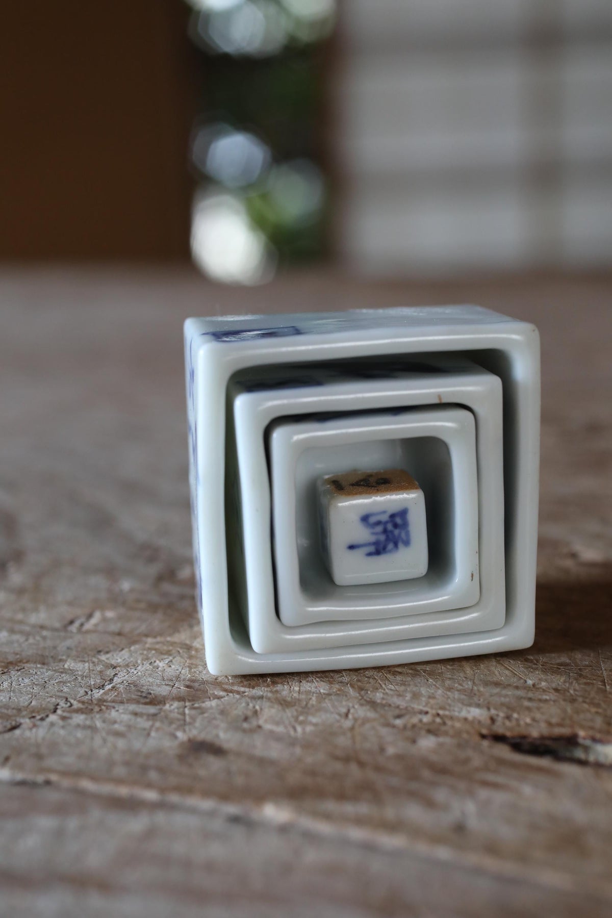 A white ceramic container with a blue design sits on a wooden surface.