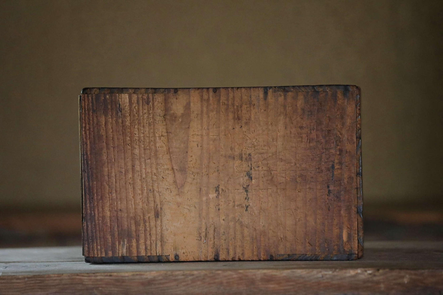 A weathered, wooden surface with a rough, textured appearance.