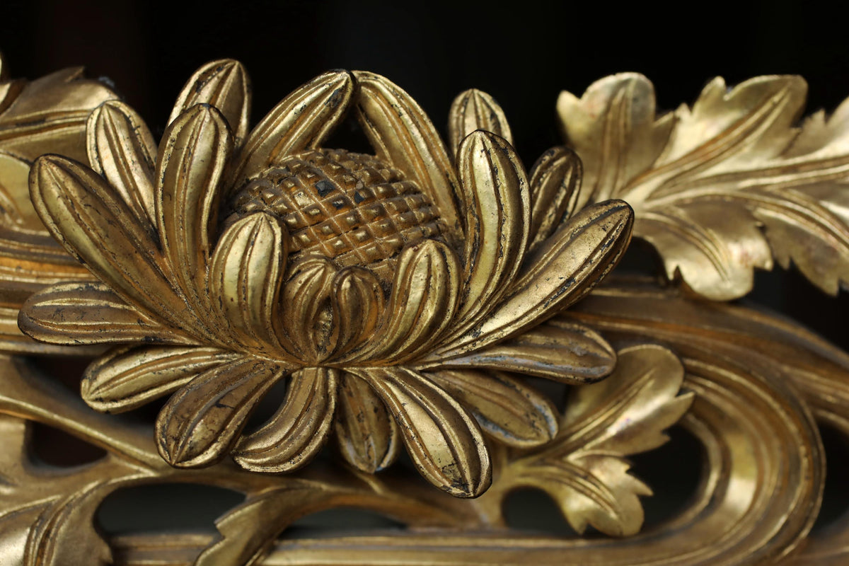 a close-up view of a detailed, intricately carved golden flower with multiple petals and a central bloom.