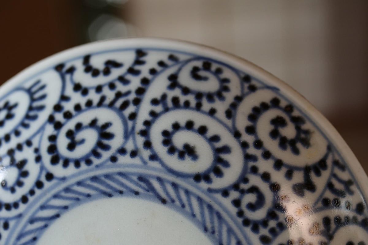 A close-up view of a decorative blue and white plate with intricate swirl patterns.