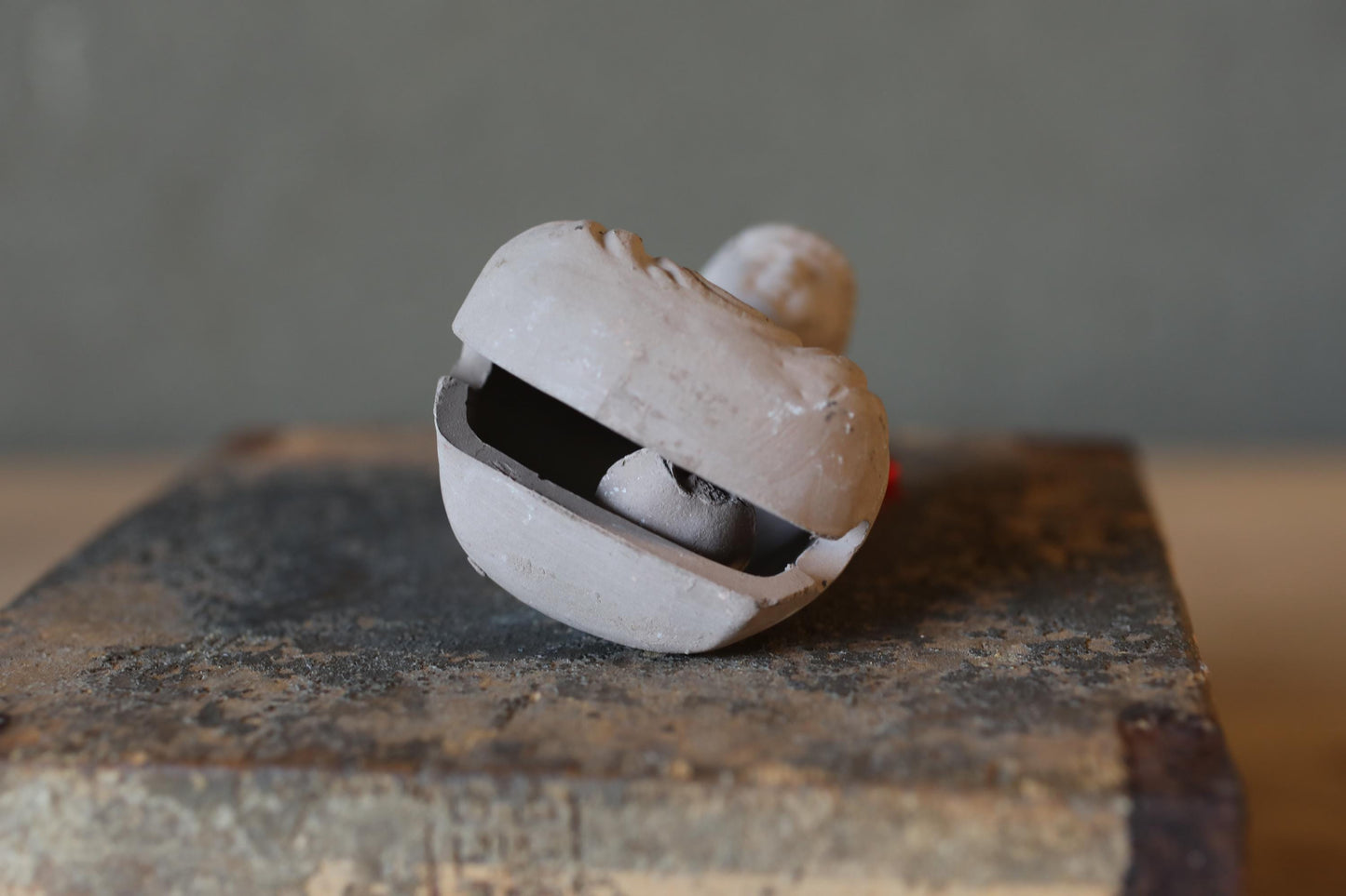 A ceramic object, possibly a vase or bowl, is shown in the image, with a textured surface and a slightly tilted position.