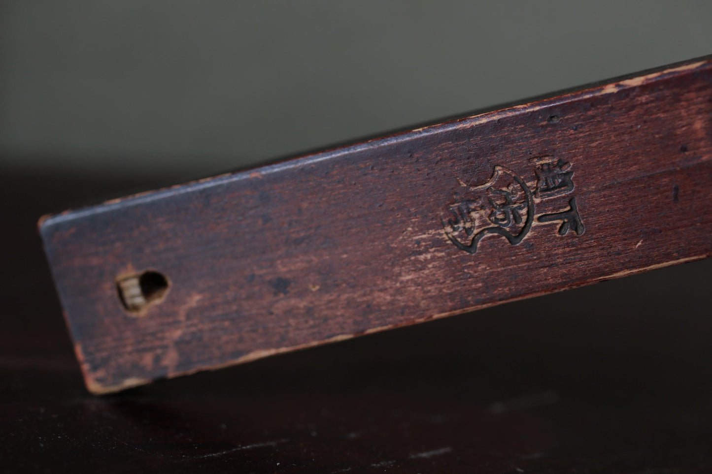 a close-up view of a wooden object with a carved design on it.