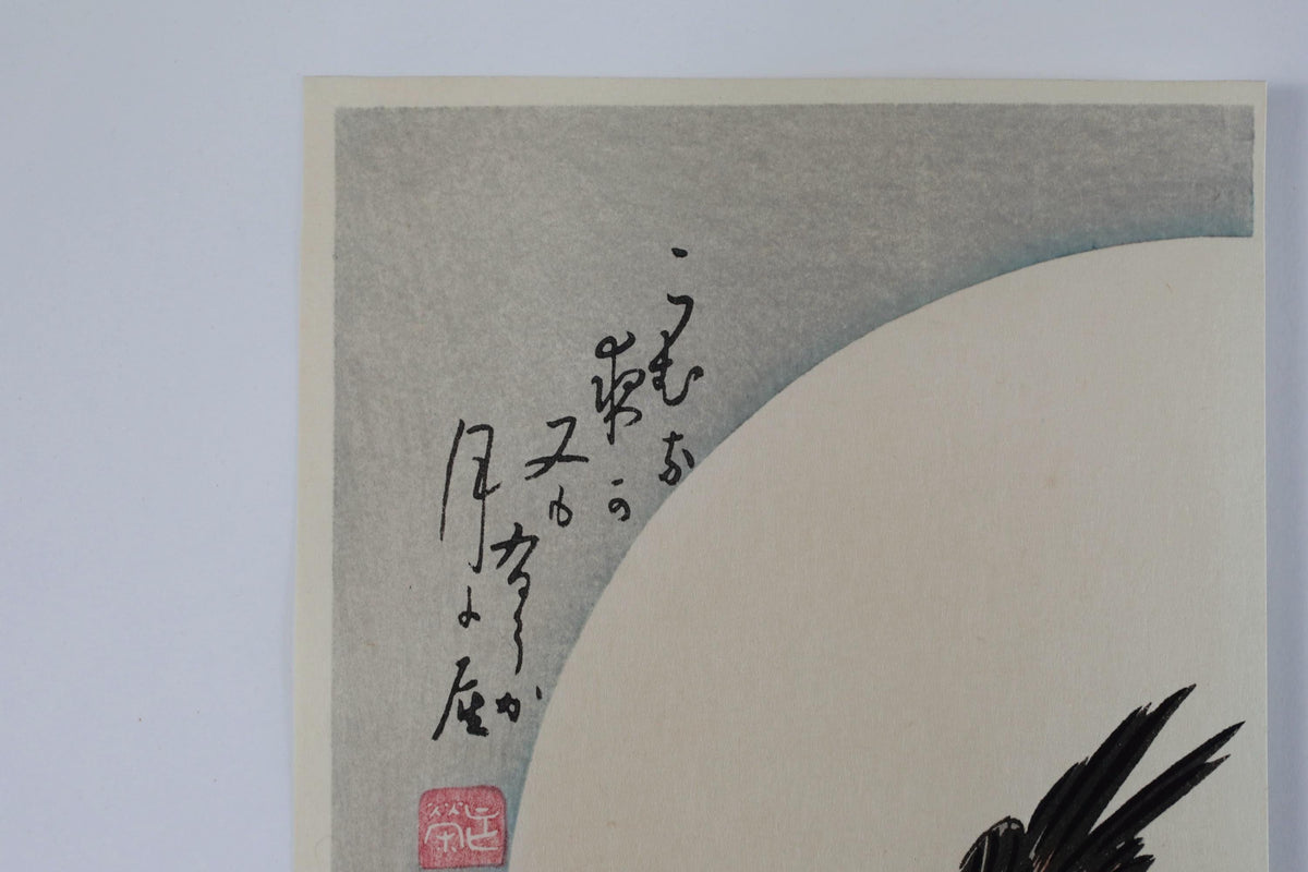 a close-up view of a piece of art with a large, circular shape in the background and some Japanese text written in the corner.