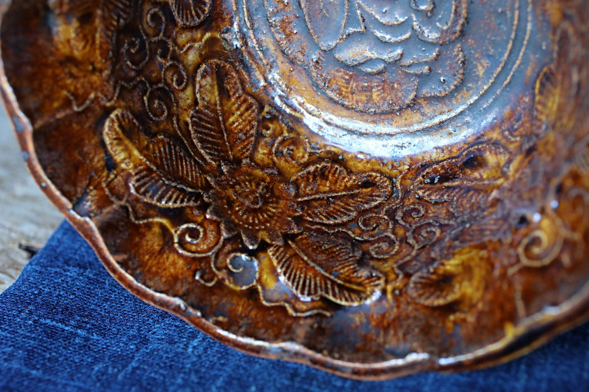 a close-up view of a decorative ceramic bowl with intricate floral patterns and designs.