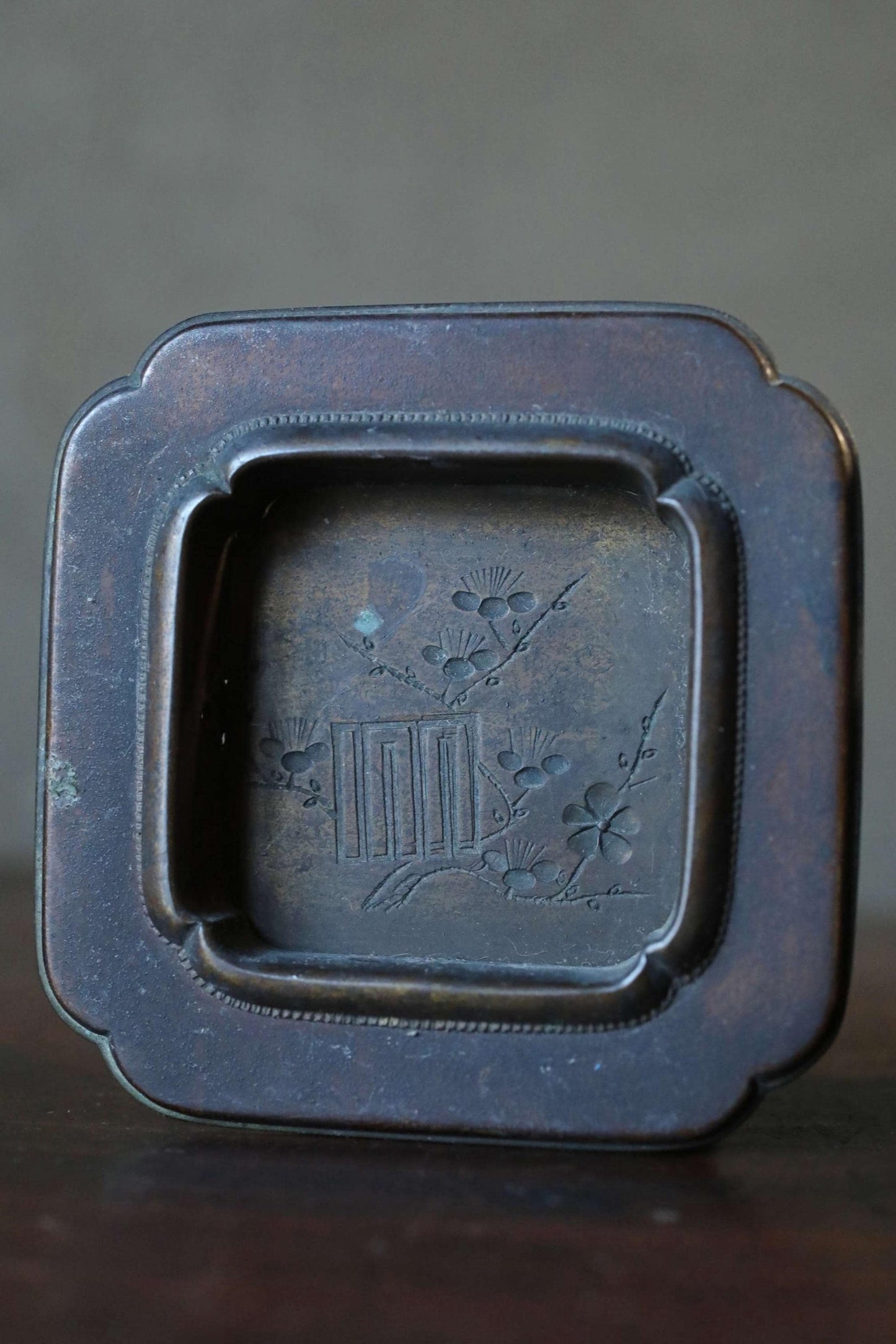 a square metal tray with a decorative design on it.