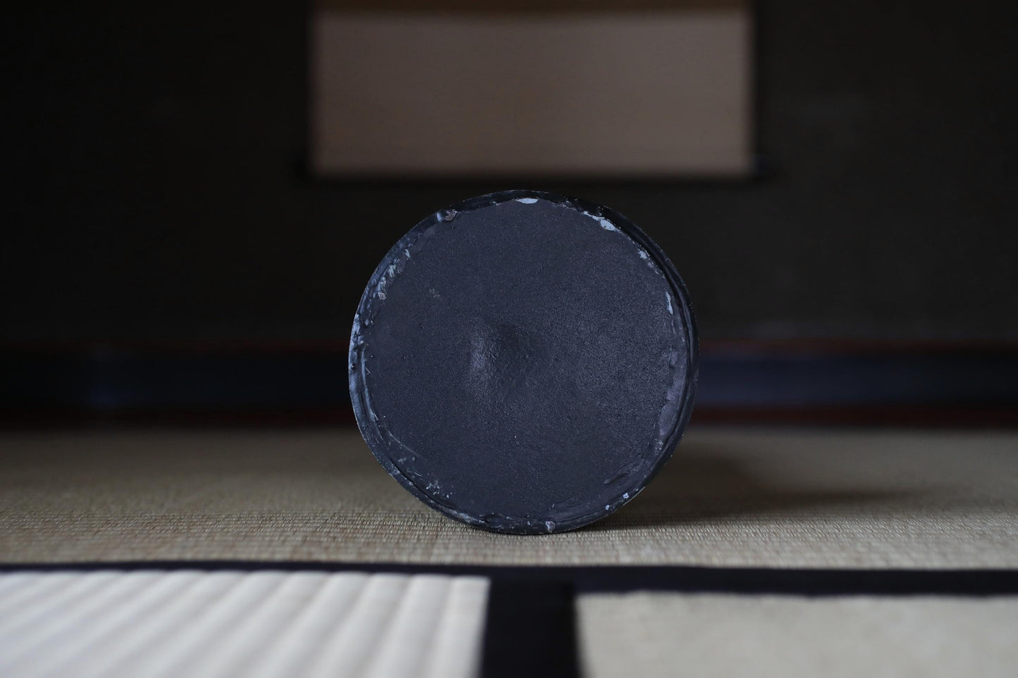 a black object, possibly a piece of furniture or a decorative item, sitting on a white surface.