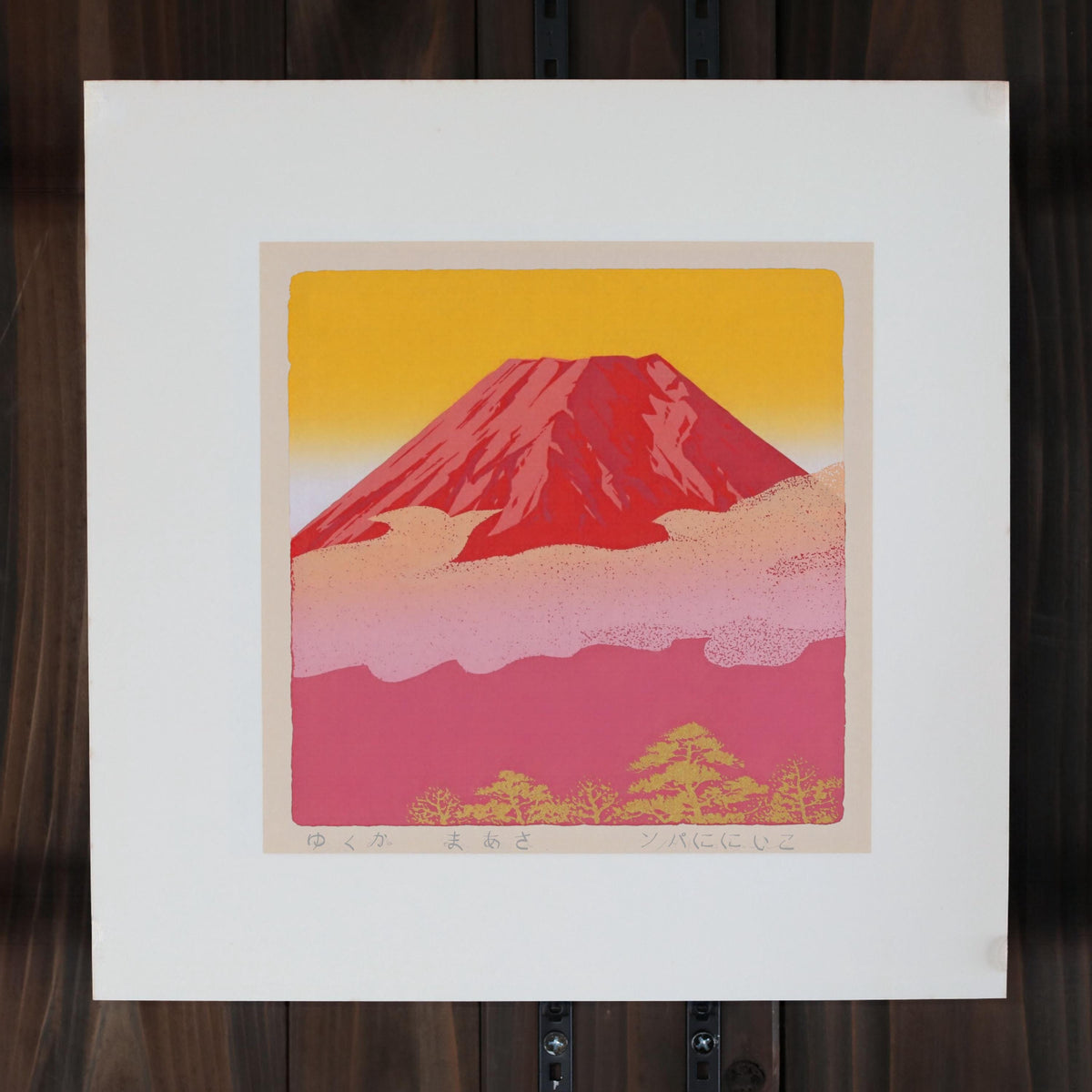 a vibrant red mountain against a warm yellow and pink sky, with a few trees visible in the background.