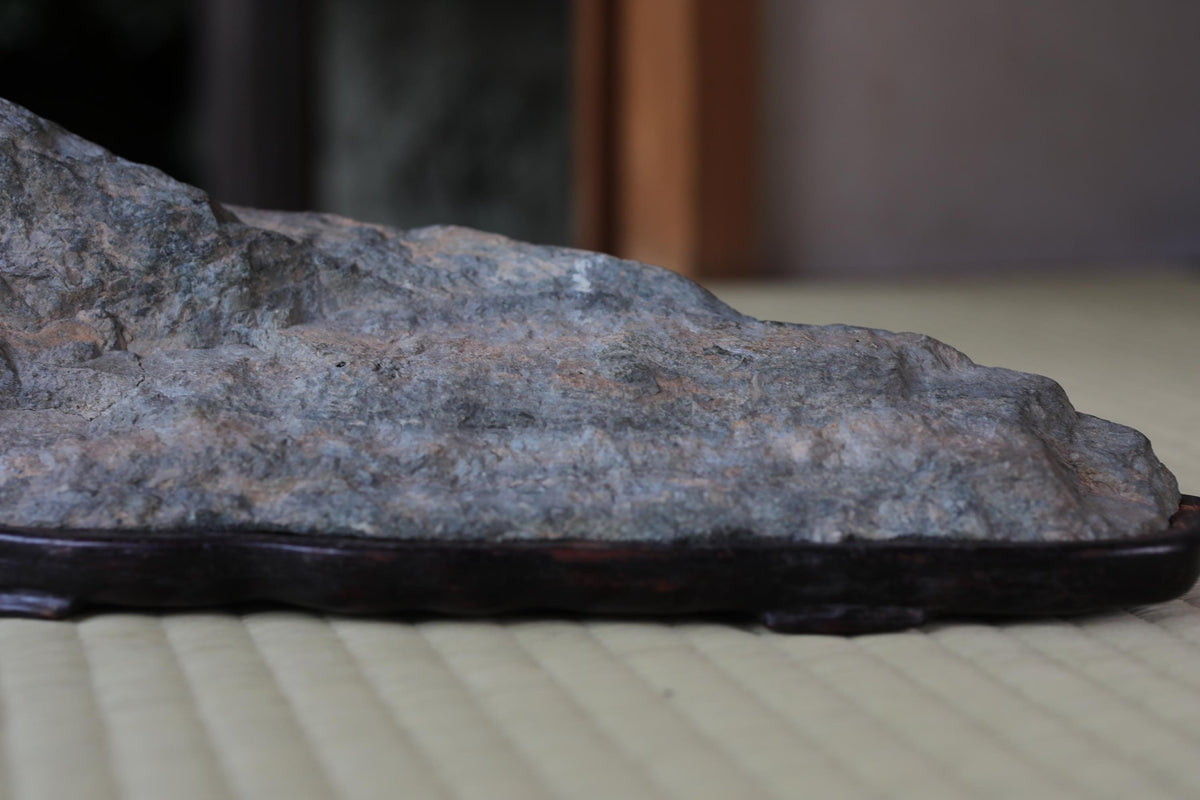A close-up image of a rock or stone placed on a wooden base or stand.