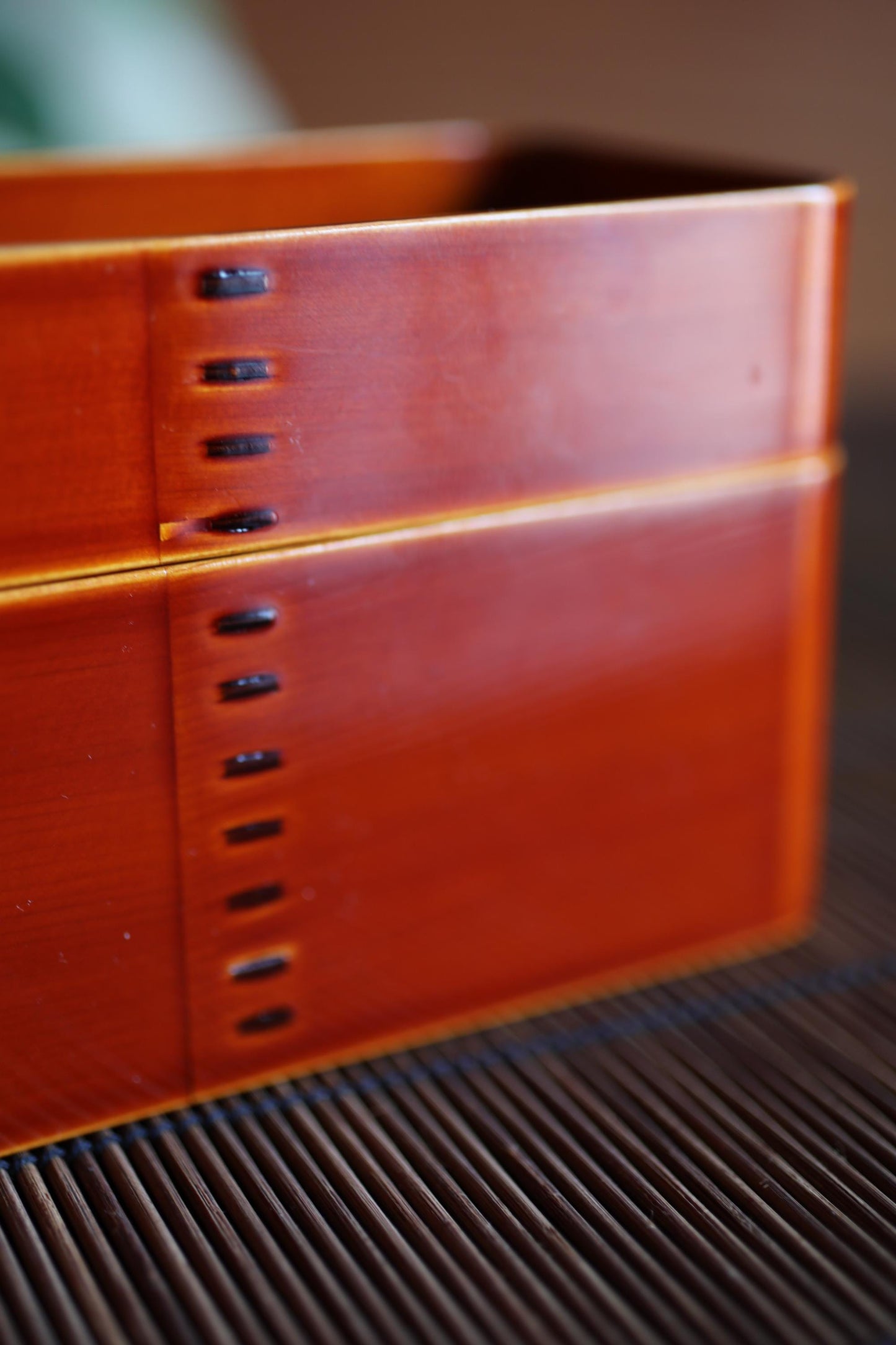 a close-up view of a red object with a series of small holes or punctures along its surface.