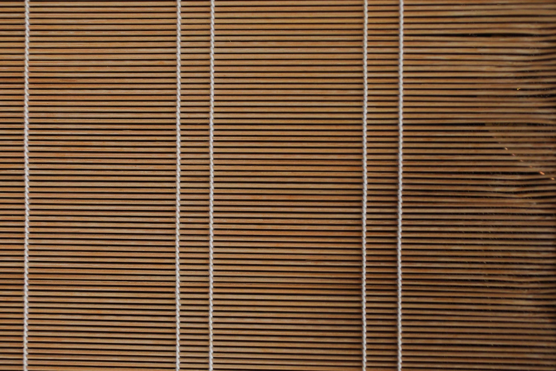 a close-up view of a wooden blind with vertical slats, creating a textured and patterned appearance.