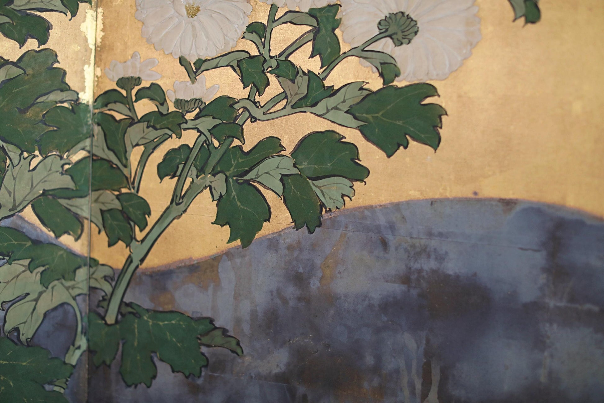 The image is a close-up of a painting featuring a branch with green leaves and white flowers against a blue background.