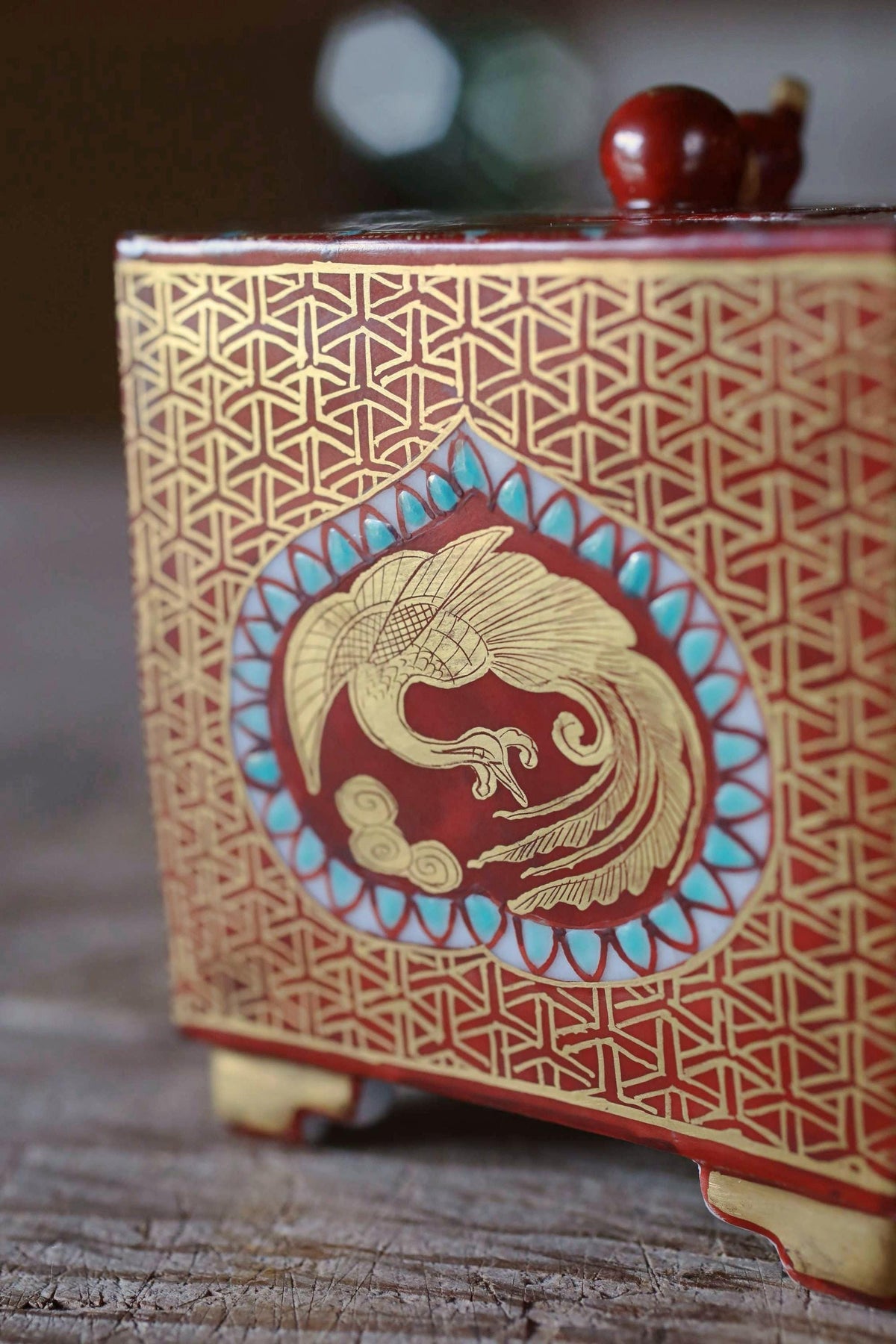 A red and gold decorative box with a gold and blue floral design on the front.