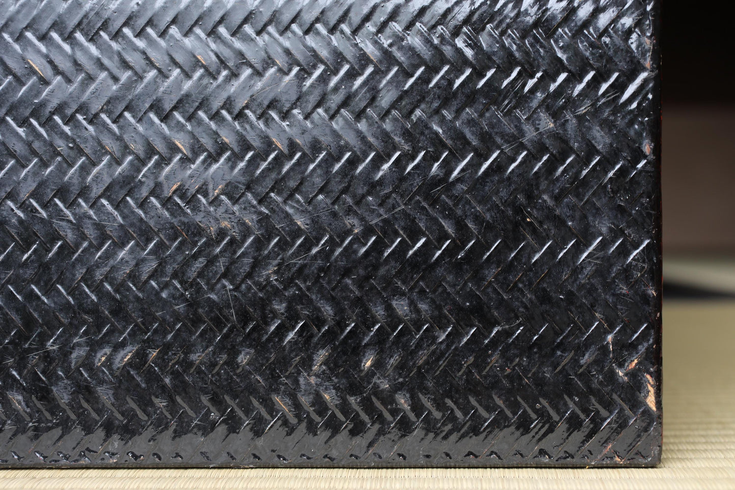 a close-up view of a black, textured surface with a zigzag pattern.