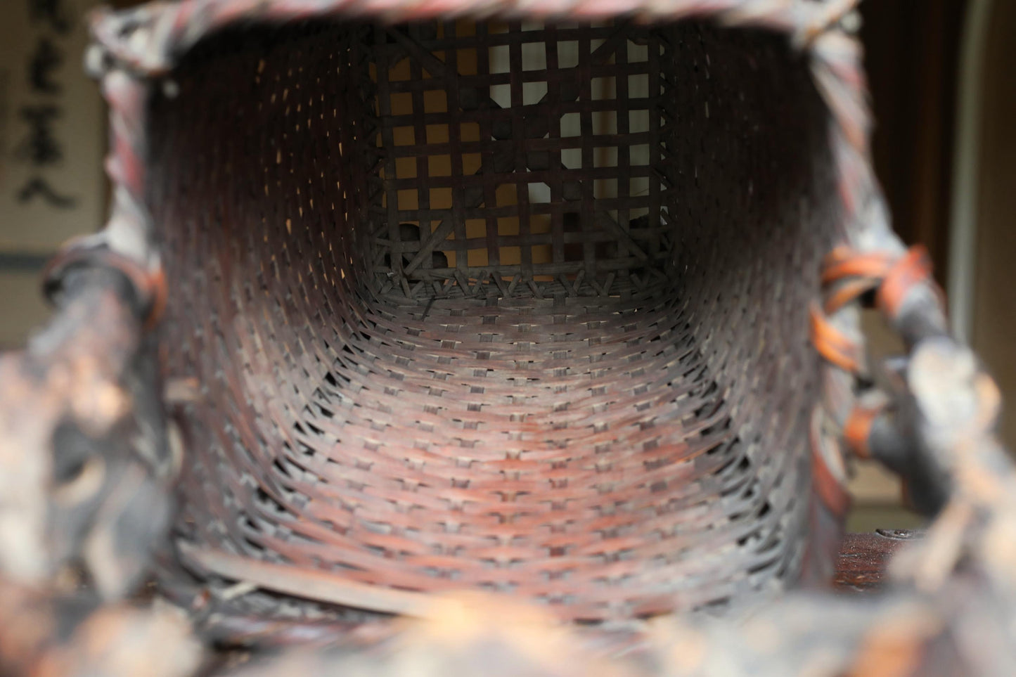 an old, weathered basket with a woven texture, sitting on a surface.