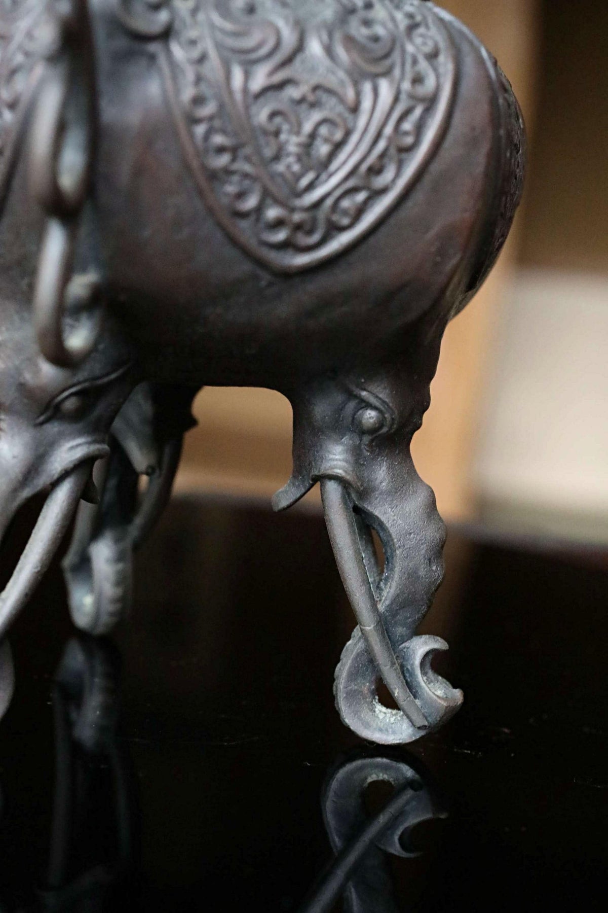 A close-up view of a decorative metal elephant figurine, featuring intricate patterns and designs on its surface.