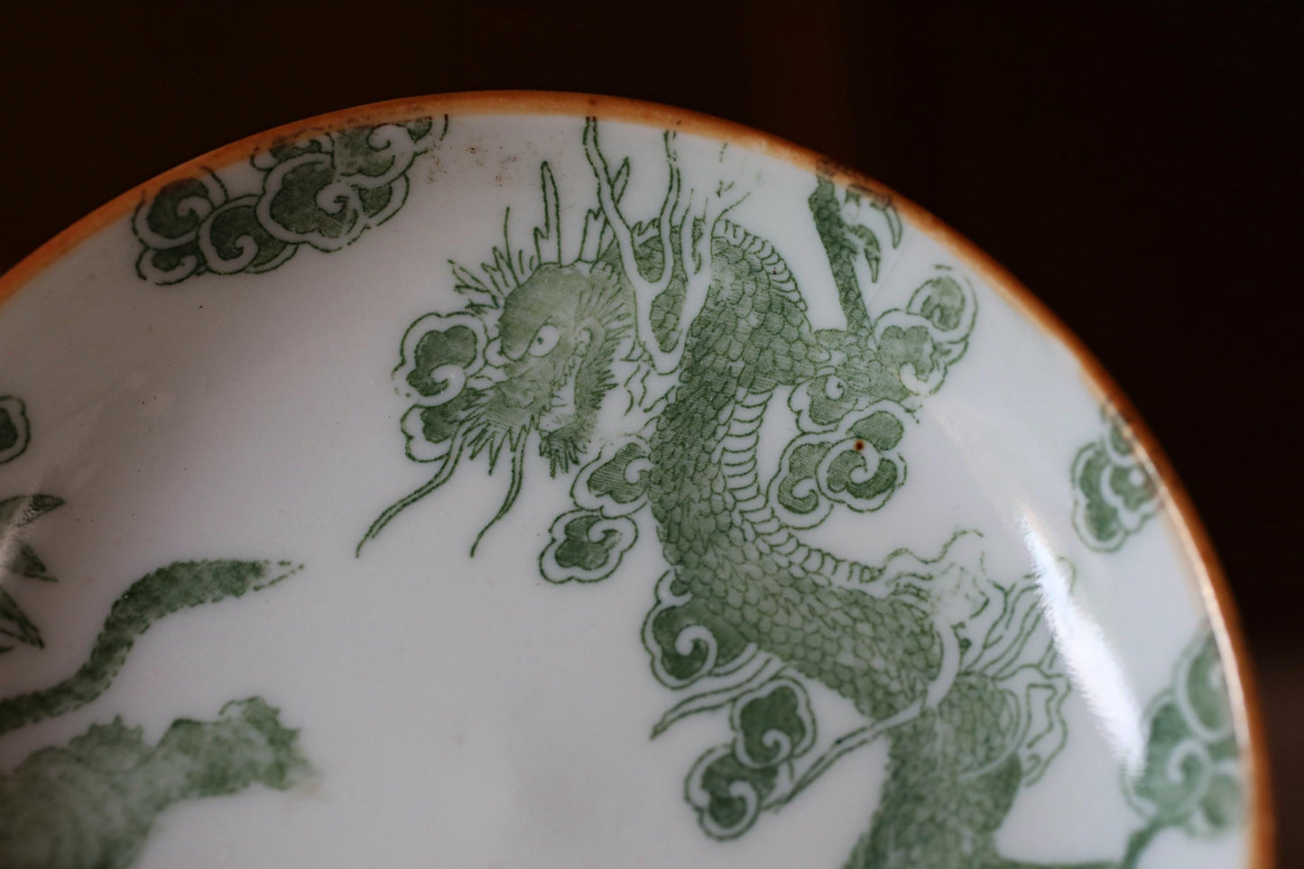 A close-up image of a decorative plate with a green dragon design.