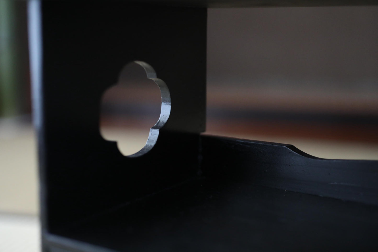 A close-up view of a black metal object with a cutout shape, possibly a piece of furniture or a decorative element.