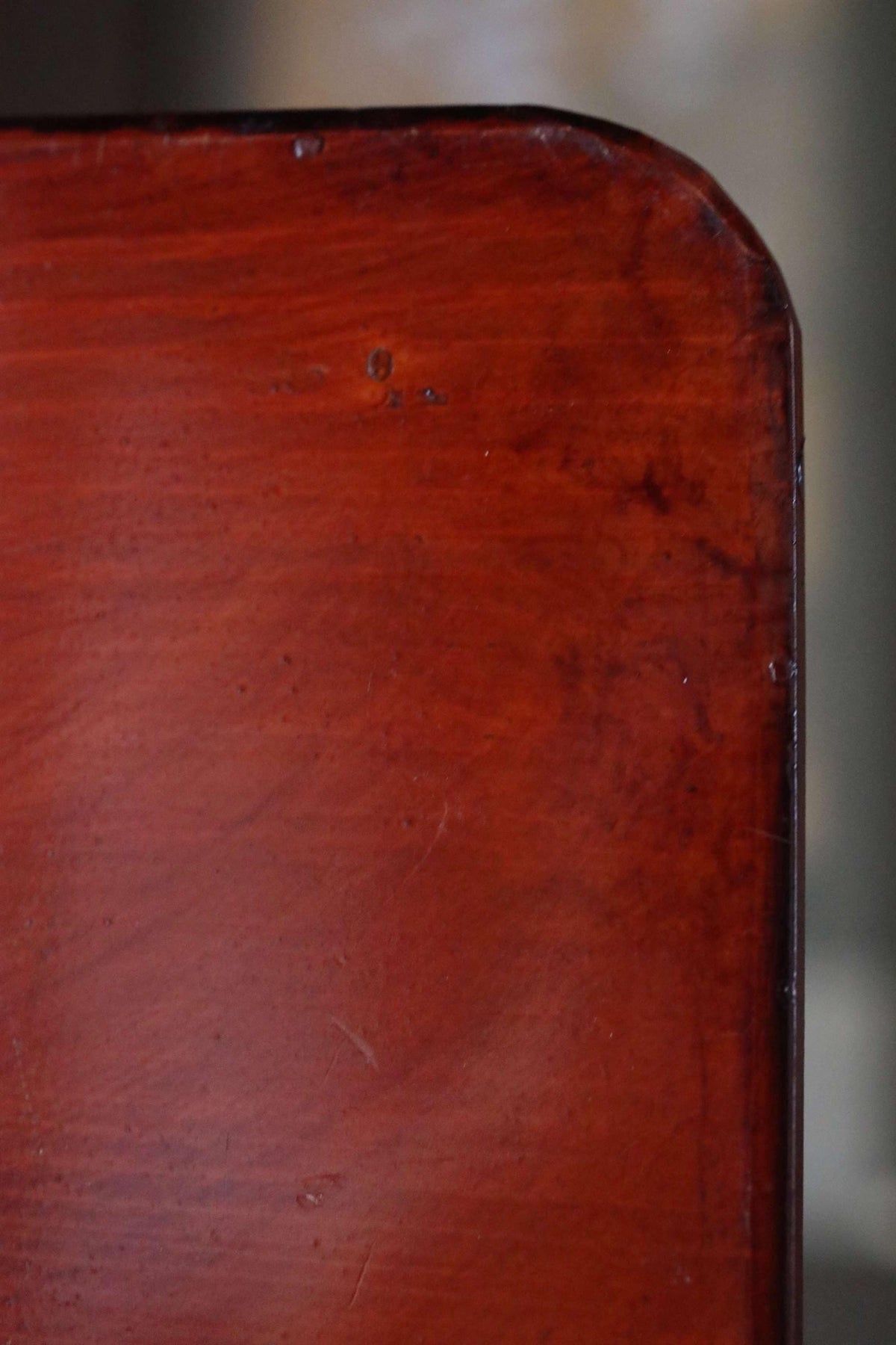 a close-up view of a wooden surface, possibly a table or a piece of furniture, with a rich, warm brown color and visible grain patterns.
